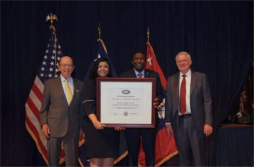 Mayor Dale V.C. Holness and Paola Isaac Baraya Receive President's "E" Award for Export Service from Secretary of Commerce Wilbur Rosson.